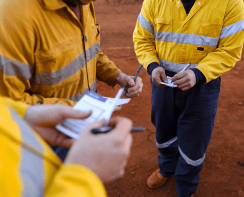 a group of men in yellow jackets carrying out risk assessment