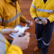 a group of men in yellow jackets carrying out risk assessment